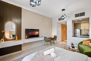 ein Wohnzimmer mit einem grünen Sofa und einem TV in der Unterkunft Luxurious Apt Near Jbr in Dubai