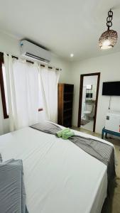 ein Schlafzimmer mit einem großen weißen Bett in einem Zimmer in der Unterkunft Pousada Bilica in Arraial d'Ajuda