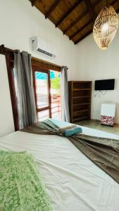 a large bed in a room with a window at Pousada Bilica in Arraial d'Ajuda