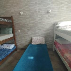 Zimmer mit 2 Etagenbetten und einem blauen Teppich in der Unterkunft Vila do Chaves bed breakfast in São Paulo