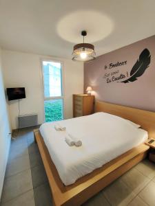 1 dormitorio con 1 cama blanca grande y 2 almohadas en Appartement T3 avec piscine, climatisation, wifi et garage en Collioure