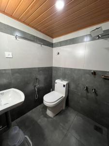 a bathroom with a toilet and a sink at Kovilakam Achutham in Guruvāyūr
