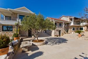 a villa with a tree in a driveway at Villa Žurnata in Bogomolje +52 photos