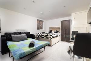 a living room with a couch and a table at Garden Studio flat in Hendon in Hendon