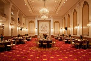 Un salón de banquetes con mesas, sillas y candelabros. en New Yorker by Lotte Hotels, en Nueva York