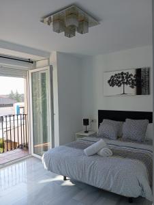 Habitación blanca con cama y balcón. en El Diez de Sultana, en Granada