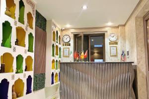 a room with clocks on the wall and a bench at NANOSH EAST HOTEL in Bukhara