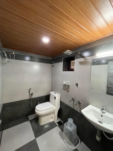 uma casa de banho com um WC e um lavatório em Kovilakam Achutham em Guruvāyūr