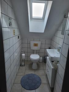 a small bathroom with a toilet and a sink at Appartement Ferienwohnung in Hövelhof +4 photos