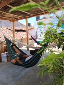 2 personen in hangmatten op een patio bij ADVENTURE Hostel in San Gil