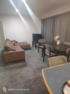 a living room with couches and a table and a couch at Cozy Double Room - WIFI in Hamilton