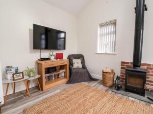 a living room with a fireplace and a flat screen tv at Ashtree Cottage in Hull