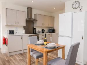 a kitchen with a wooden table and chairs in a kitchen at Ashtree Cottage in Hull