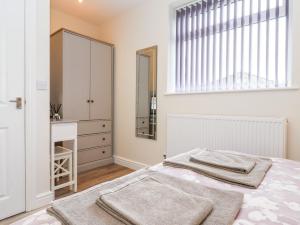 a bedroom with a bed and a sink and a mirror at Ashtree Cottage in Hull