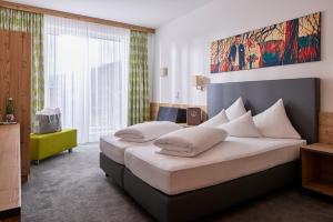 sypialnia z 2 łóżkami i dużym oknem w obiekcie Hotel Zontaja Superior w mieście Galtür