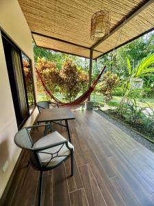a porch with two chairs and a hammock at Villa Tucan in Fortuna