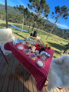 una mesa de picnic con comida en la cubierta en Estalagem Santa Clara en Urubici