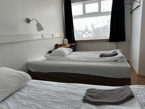 two twin beds in a room with a window at Kanslarinn Hostel in Hella