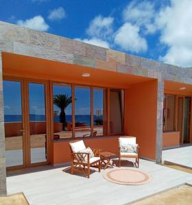 uma casa com um pátio com duas cadeiras e uma mesa em Praia Encantada em Porto Santo