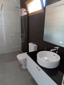 Łazienka z białą toaletą i umywalką w obiekcie Praia Encantada w mieście Porto Santo
