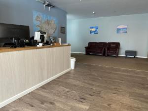 a waiting area of a waiting room with a counter and chairs at Kanslarinn Hostel in Hella