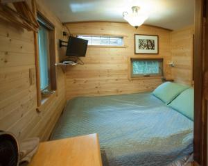 a small bedroom with a bed in a wooden room at The Treecycle in Austin