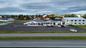 a large white building with a parking lot in front of it at Kanslarinn Hostel in Hella