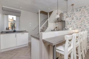 a kitchen with white cabinets and a sink and a counter at Brunswick Cottage, Penrith, The Lake District in Penrith