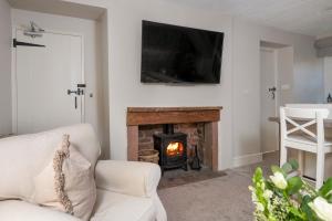 a living room with a fireplace and a tv at Brunswick Cottage in Penrith