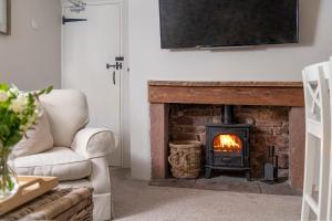 a living room with a fireplace with a tv above it at Brunswick Cottage in Penrith