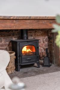 a black stove in a brick fireplace at Brunswick Cottage in Penrith