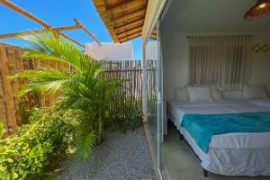 Schlafzimmer mit einem Bett auf einem Balkon in der Unterkunft Villa Nahum ER Hospedagens in São Miguel dos Milagres