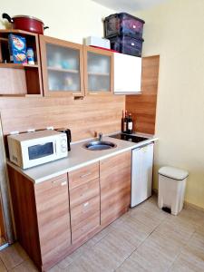 a small kitchen with a sink and a microwave at Pool View Apartment, Sunny Beach Resort in Sunny Beach