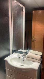 Apartamento Riglos2 Candanchu في كاندانتشو: حمام مع حوض أبيض ومرآة