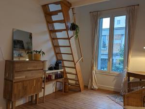 Zimmer mit Holztreppe und Fenster in der Unterkunft Chambre bohème au calme in Montrouge