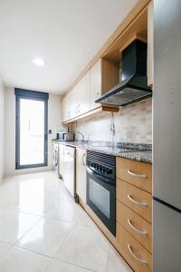 uma grande cozinha com electrodomésticos brancos e uma janela em Lujoso apartamento de dos habitaciones en la playa de Canet em Canet d'En Berenguer