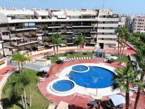 uma vista superior de uma piscina em frente a um edifício em Lujoso apartamento de dos habitaciones en la playa de Canet em Canet d'En Berenguer