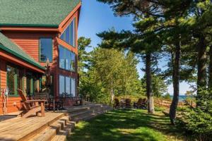 un porche de una casa con terraza de madera en Lake Superior Cabin with Fireplace Snowmobile Trails, en Paradise