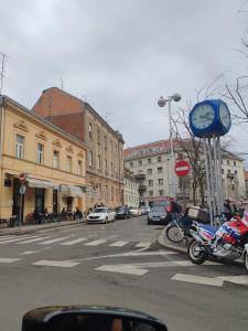 uma rua da cidade com carros e um relógio num poste em Britstreet apartment em Zagreb