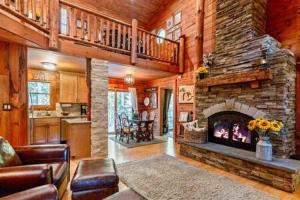 a living room with a stone fireplace in a house at Torch Lake Cabin In The Woods THE HEART OF TORCH in Bellaire