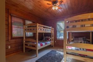 a bedroom with two bunk beds in a cabin at Torch Lake Cabin In The Woods THE HEART OF TORCH in Bellaire
