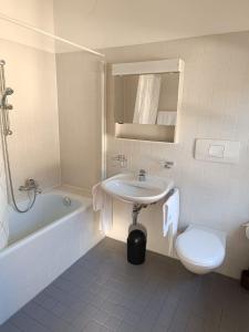 a white bathroom with a sink and a toilet at Locanda La Pignatta in Arogno
