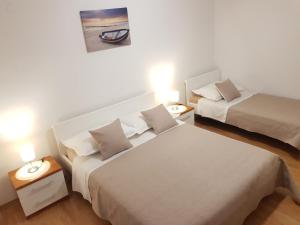 a hotel room with two beds and two lamps at Accommodation Huljić in Hvar