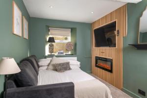a living room with a couch and a fireplace at Gibson Cottage, Penrith, The Lake District in Penrith