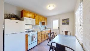a kitchen with a white refrigerator and a table with chairs at Downtown Cozy Home Base - Purple Sage 4 in Moab