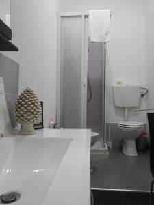 a white bathroom with a toilet and a shower at Artemide Rent BedRooms in Agrigento +72 photos