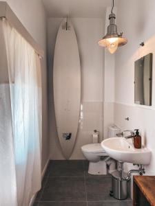 a bathroom with a sink and a surfboard on the wall at Altes Dorfhaus Sechzehneichen 