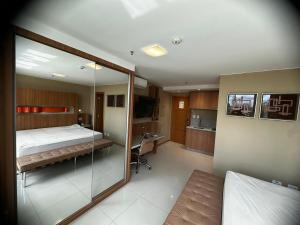 Flat no Jade Hotel في برازيليا: غرفة نوم بسرير ومرآة