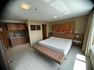 um quarto com uma cama grande num quarto em Flat no Jade Hotel em Brasília