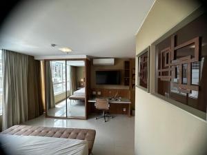 Habitación de hotel con cama y escritorio. en Flat no Jade Hotel en Brasilia